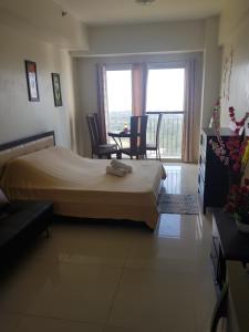 um quarto com uma cama, uma mesa e cadeiras em Wind Residences Tower 4 em Kaybagal mais 22 fotografias