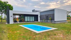 a house with a swimming pool in the yard at Guyra, Casas Boutique in Corrientes