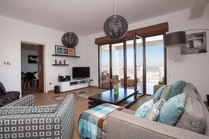 Sala de estar con 2 sofás y TV en Villa Arcadia, Kallepia, en Pafos