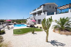 a house with a swimming pool and a palm tree at Villa Arcadia, Kallepia in Paphos