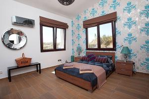 a bedroom with a large bed and a mirror at Villa Arcadia, Kallepia in Paphos City +25 photos