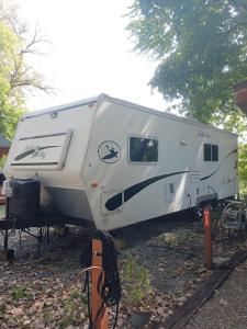 een witte trailer is geparkeerd in een tuin bij Lakeshore Glamping Camping 239 in Portage