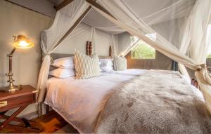 een slaapkamer met een hemelbed bij Camp Figtree by The Oyster Collection in Addo