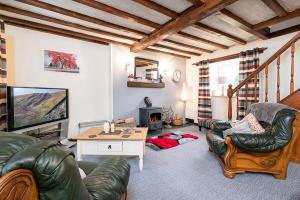 een woonkamer met twee leren stoelen en een televisie bij Pant in Llanymawddwy