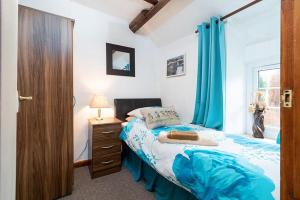 een slaapkamer met een bed en een raam met blauwe gordijnen bij Pant in Llanymawddwy