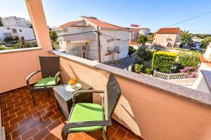 a balcony with chairs and a table on a building at Apartments Niko in Novalja