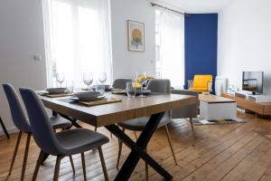 uma sala de jantar com mesa e cadeiras em Appartement spacieux em Quimper