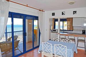 a kitchen and dining room with a view of the ocean at ShoreHouse Apartamento Primera linea Playa Honda in Playa Honda