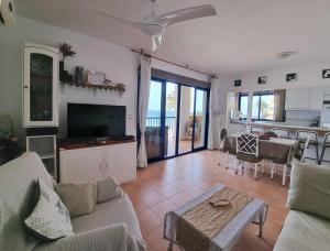 プラヤ・オンダにあるShoreHouse Apartamento Primera linea Playa Hondaのリビングルーム(ソファ、テーブル付)、キッチンが備わります。