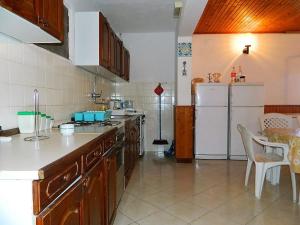a kitchen with a white refrigerator and a table at House Fani in Zastražišće