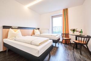 ein Hotelzimmer mit 2 Betten und einem Tisch in der Unterkunft Bielefeld JBB Jugendgästehaus in Bielefeld