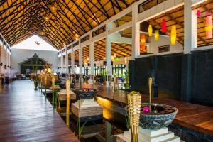 a restaurant with a long bar with tables and chairs at Amata Garden Resort, Inle Lake in Ywama