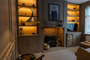 a living room with a fireplace and a lamp at The Willows in Newton-le-Willows