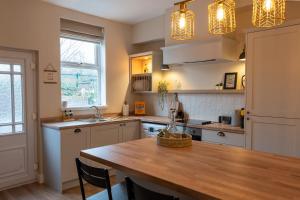 a kitchen with a wooden table and a counter top at The Willows in Newton-le-Willows