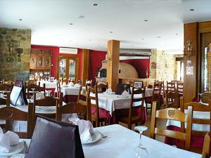 un comedor con mesas y sillas en un restaurante en Posada Ribera del Pas, en Iruz