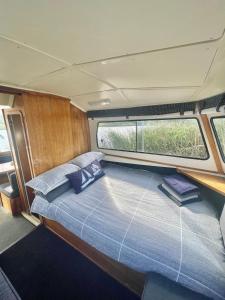 a bed in the center of a boat with a window at Houseboats - Living The Breede - Valid Skippers License compulsory in Malgas
