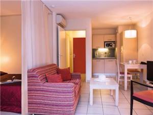 Il comprend un salon avec un canapé et une cuisine. dans l'établissement La Villa Du Lac- 3 rooms for 6 people, à Divonne-les-Bains