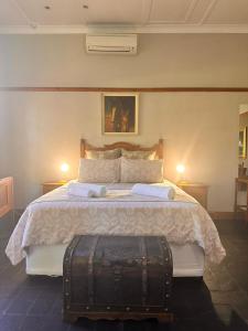 una camera da letto con un grande letto con una valigia sopra di Farm stay at Saffron Cottage on Haldon Estate a Bloemfontein