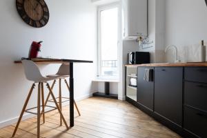 a kitchen with a counter and a table and a chair at Appartement spacieux in Quimper +9 photos