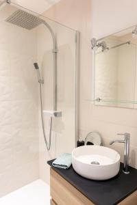 a white bathroom with a sink and a shower at Appartement spacieux in Quimper