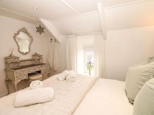 Breage的住宿－Evergreen，白色卧室配有床和书桌