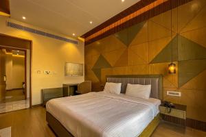 a bedroom with a large bed and a desk at Symphony Inn in Vellore
