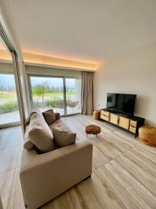 a living room with a couch and a flat screen tv at Emerald Suites in Protaras