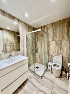 a bathroom with a toilet and a glass shower at Emerald Suites in Protaras