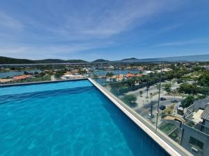 a large swimming pool with a view of a city at Flat Samba Bossa Nova in Cabo Frio