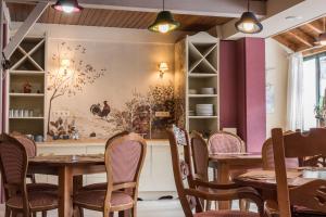 a dining room with tables and chairs and a painting on the wall at Hotel SNÖ Colomers in Salardú