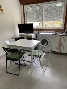 cocina con mesa, sillas y lavadora en Apartamento El Nogal 1, en Tui