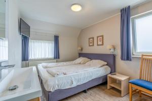 - une petite chambre avec un lit et un lavabo dans l'établissement Villapark Kamperfoelie 47, à De Koog