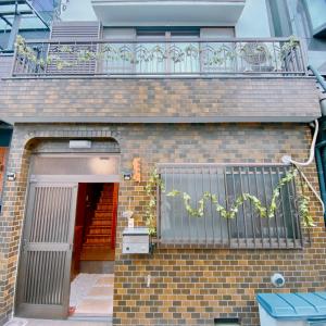un edificio de ladrillo con balcón y puerta en 悠雅軒, en Osaka