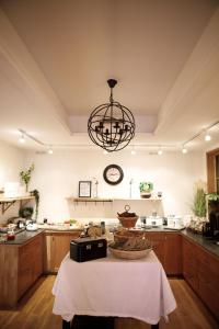 a kitchen with a table and a clock on the wall at Hotell Gute in Visby