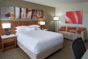 een slaapkamer met een groot wit bed en een bank bij Delta Hotels by Marriott Toronto Airport & Conference Centre in Toronto