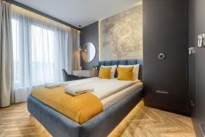 um quarto com uma cama grande e almofadas amarelas em Margi Whisky Apartament LUX AIRCON em Szczecin