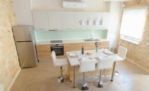 uma cozinha com uma mesa e cadeiras brancas e um frigorífico em Villa Nuelle em Tílisos