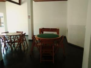 um quarto com uma mesa verde e algumas cadeiras em AP DANTAS em Caraguatatuba