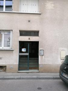 una puerta a un edificio con una señal en él en Côté Perdrix - Calme - Centre Ville - Animaux admis, en Dijon