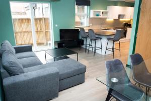 ロンドンにあるSpacious Clapham Apartmentsのリビングルーム(ソファ、椅子付)、キッチンが備わります。