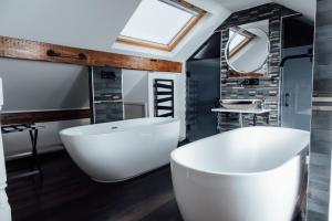 Arthur's Bar & Accommodation في ساوثبورت: حمام مع حوض أبيض كبير ومغسلة