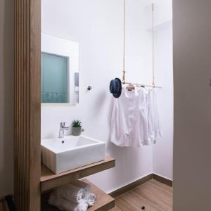 uma casa de banho com um lavatório branco e um espelho. em Ermis Luxury Suites & Apartments em Amoudara Herakliou