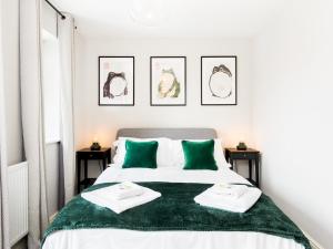 1 dormitorio con 1 cama con 2 almohadas verdes en Pass the Keys 8 Foundry Walk Stylish House with Parking en Birmingham