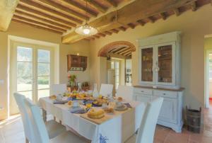 una sala da pranzo con tavolo e sedie bianchi di SUNRISE a Capannori