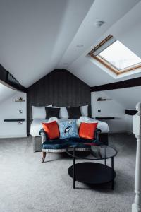 紹斯波特的住宿－Arthur's Bar & Accommodation，一间卧室配有一张床和一张蓝色沙发及红色枕头