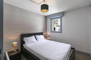 Schlafzimmer mit einem Bett mit weißer Bettwäsche und einem Fenster in der Unterkunft L'Esquiròu - Proche pistes pour 6 in Barèges