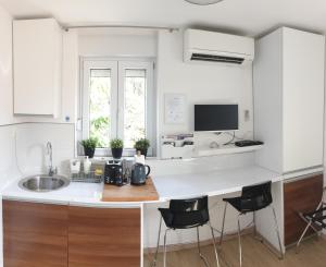 a kitchen with a sink and a counter with stools at Blue Star Apartments in Dubrovnik