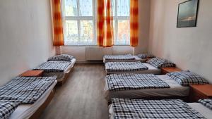szereg łóżek w pokoju z oknami w obiekcie A Plus Hostel - Centrum w Pradze