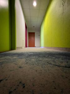 ein leeres Zimmer mit grünen und gelben Wänden in der Unterkunft Green Vilnius Hotel in Vilnius