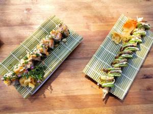 two plates of sushi on a wooden table at Nsaho resort in Fort Portal